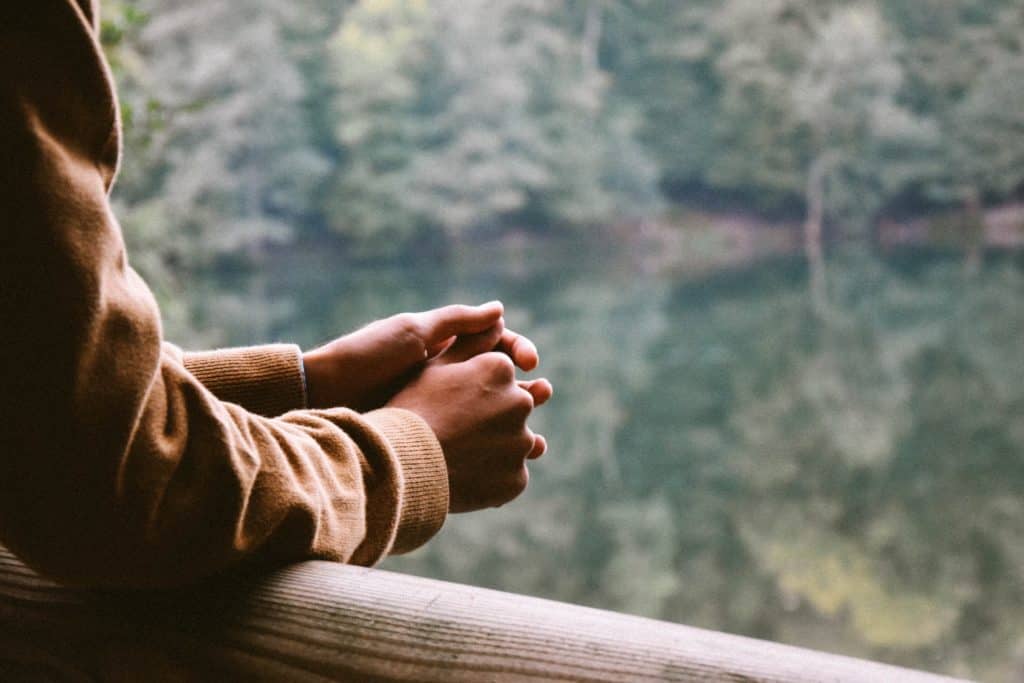 A man rests his arms on an outdoor porch as he contemplates dual diagnosis treatment in San Diego.