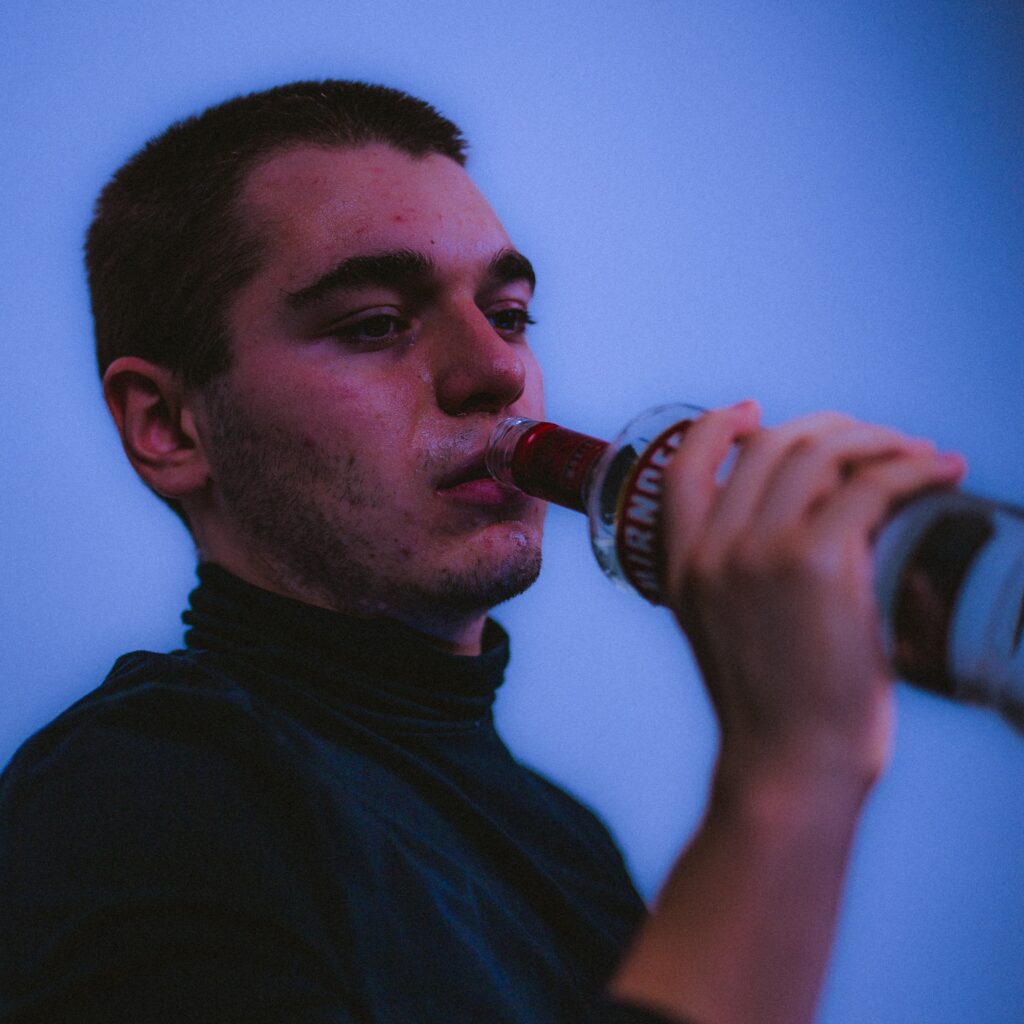 destitute man drinking in agony