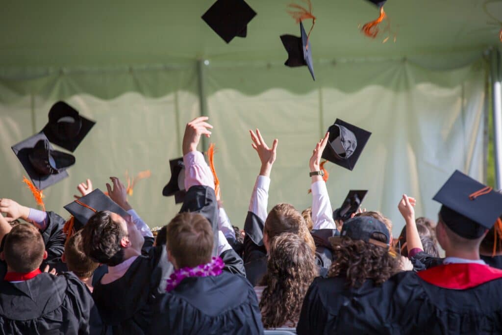 Graduating students throwing their caps in the air.