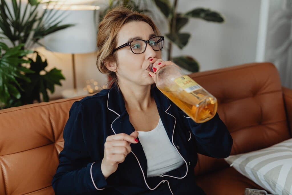 a woman drinking from the glass bottle