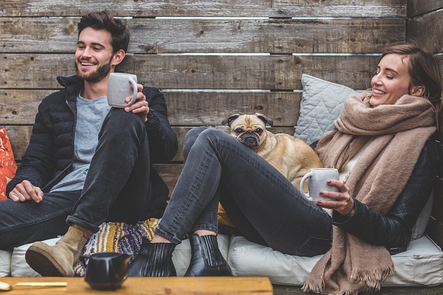 Two people relaxing in chairs with a pug.